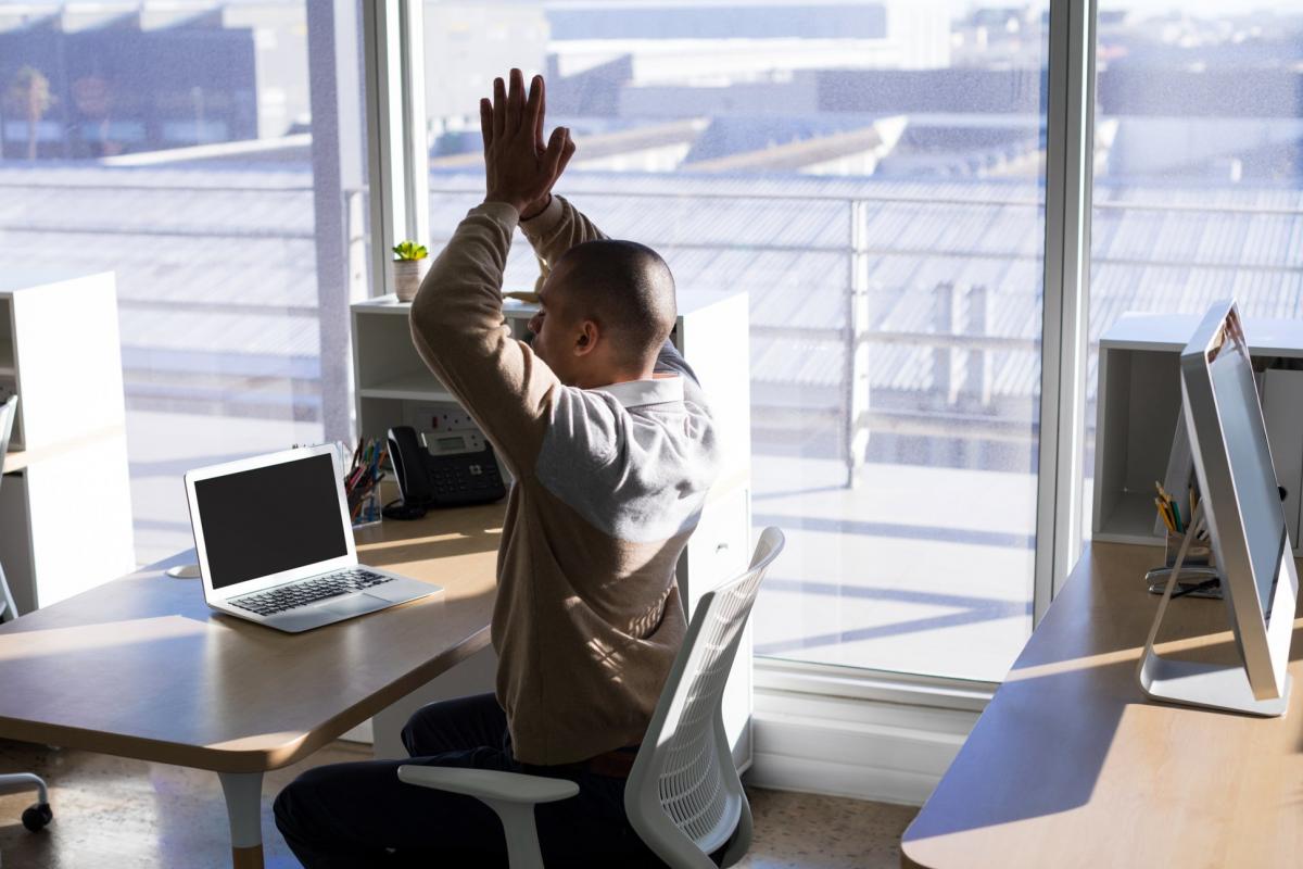 Étirement du haut du dos réalisé assis à un bureau